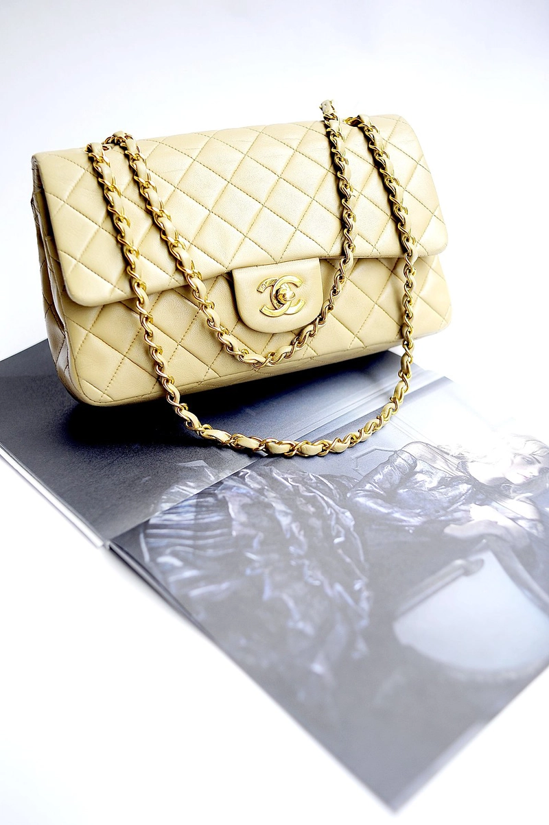 Chanel Classic Flap Bag in a light beige or yellow hue with gold hardware. 