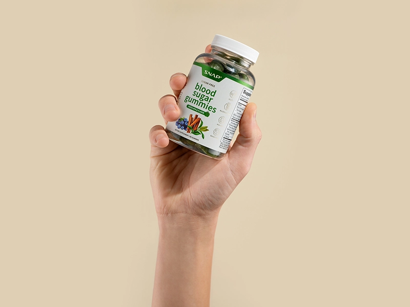 Retouched product photos using focus stacking for a Snap Supplements vitamin advertising campaign. A hand holds a bottle of vitamins against a yellow studio background.